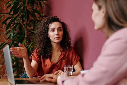 pexels-photo-4340219-4340219 Two women discuss business ideas in a cozy café setting.